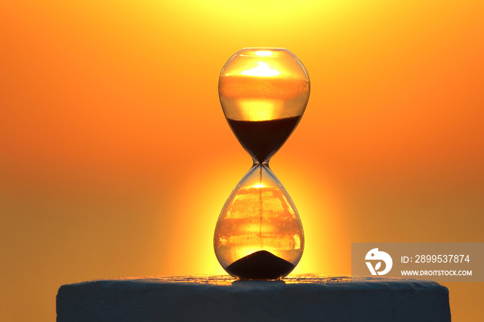 Hourglass with sunset background,  Time management concept