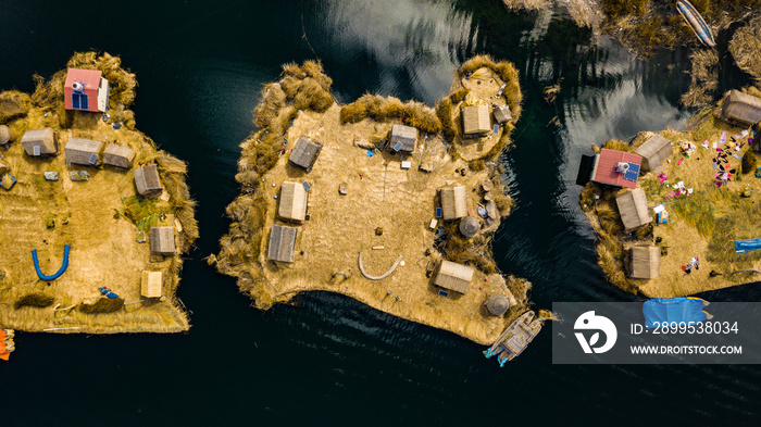 Aerial top view photo of floating islands on Lake Titicaca in Peru - a habitant of indigenous community Uros who are living on floating self-made islands made of totora plant