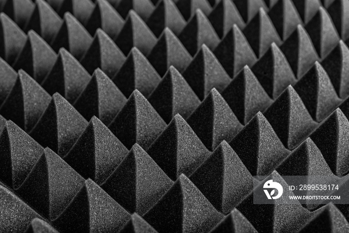 Abstract background in the form of pyramids and dragon scales. Acoustic black foam rubber.