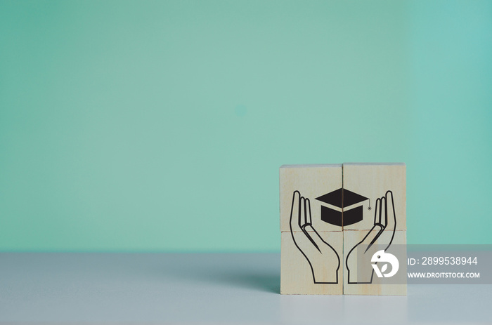 Wooden cube with graduation cap icon.Education concept. Graduation day success on background copy space.