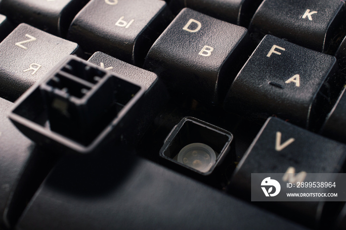 Black broken keyboard, without a button. Macro. Close up.