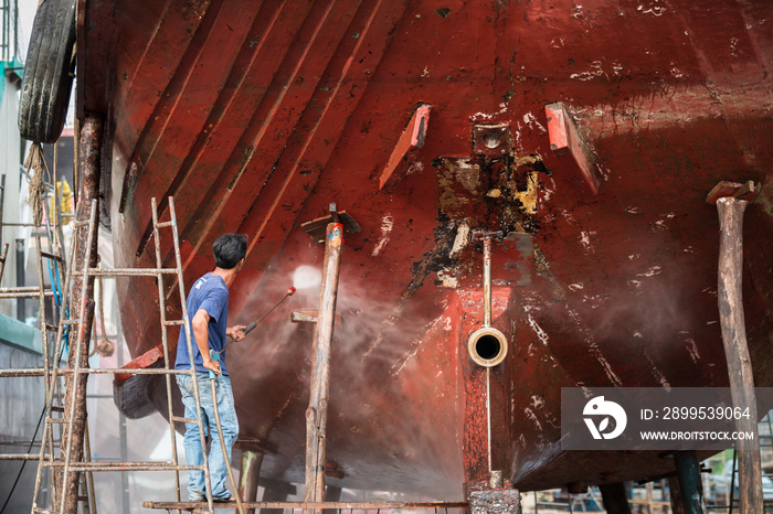 Man working on pressure washer to cleaning boat hull barnacles a