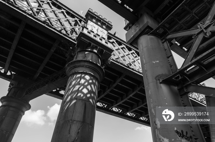 Black and white image of imposing steel viaduct structures that date back to the nineteenth century industrial period in the Castlefield district of central Manchester.