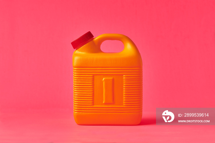 Yellow plastic bottle for mezcal on a pink background. Traditional container for storing liquids.