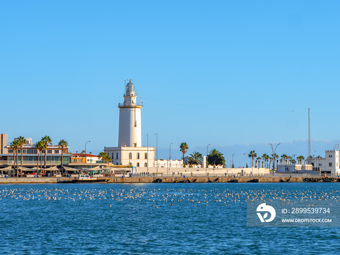 Wies of the port of Malaga.  Muelle Uno  shopping mall,Malagueta buildings and La Farola lighthouse in the background.