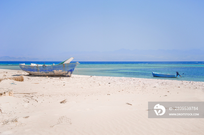 old wooden fishing boats resting on the beach of the bay blue lagoon in egypt