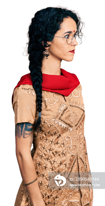 Young indian woman wearing traditional dress and glasses looking to side, relax profile pose with natural face with confident smile.