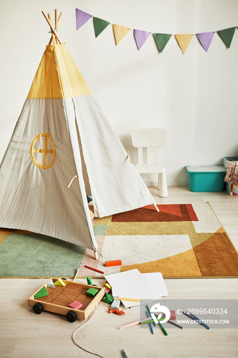 Vertical background image of cute kids room interior with play tent and decor in pastel colors