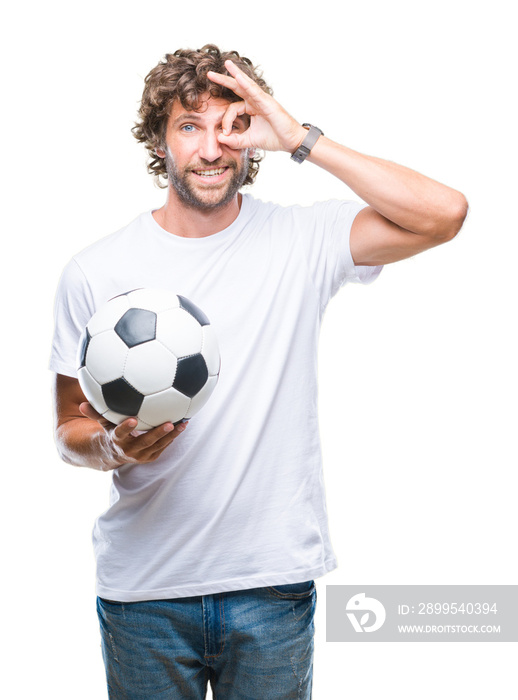 Handsome hispanic man model holding soccer football ball over isolated background with happy face smiling doing ok sign with hand on eye looking through fingers