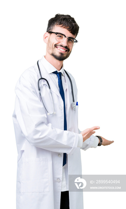 Young doctor man wearing hospital coat over isolated background Inviting to enter smiling natural with open hand