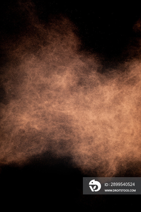Flying cocoa powder on isolated black background, brown chocolate dust cloud. Creative sweet hurricane storm tornado concept, copy text space. Dark sand abstract screensaver, explosion burst texture