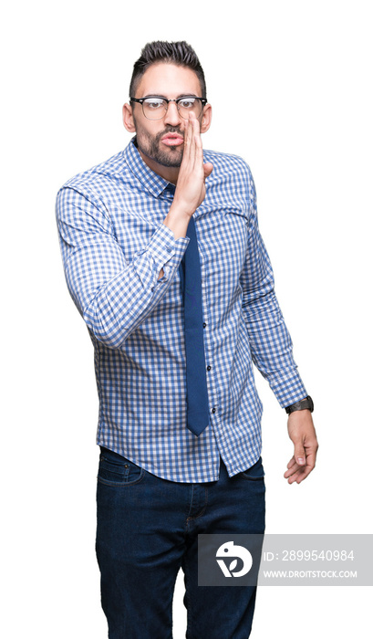 Young business man wearing glasses over isolated background hand on mouth telling secret rumor, whispering malicious talk conversation