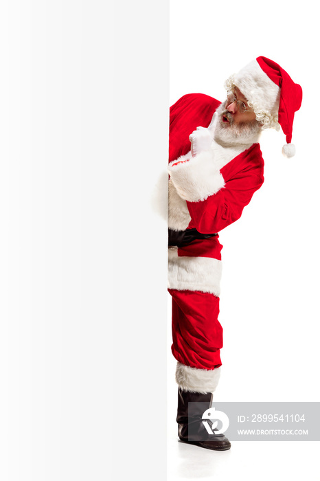 Happy surprised Santa Claus pointing on blank advertisement banner background with copy space. Smiling senior man showing at white blank of empty poster