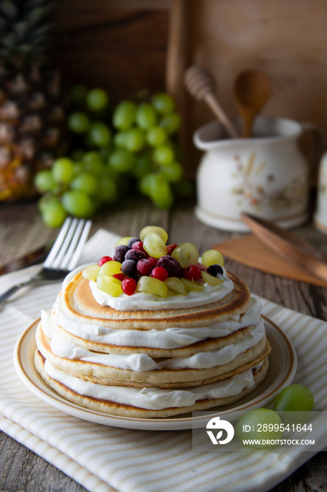 Stack of homemade pancakes or crepes with cream, yougurt fresh berries. Delicious breakfast. Pastry. Healthy food.