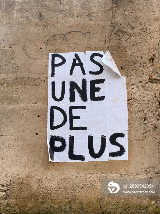 Protest poster against domestic violence and femicide stuck on a wall in Paris France, saying  not one more