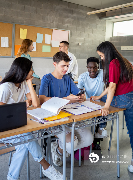 Group of multi-ethnic students talking in class during a break. High school, back to school, diverse students