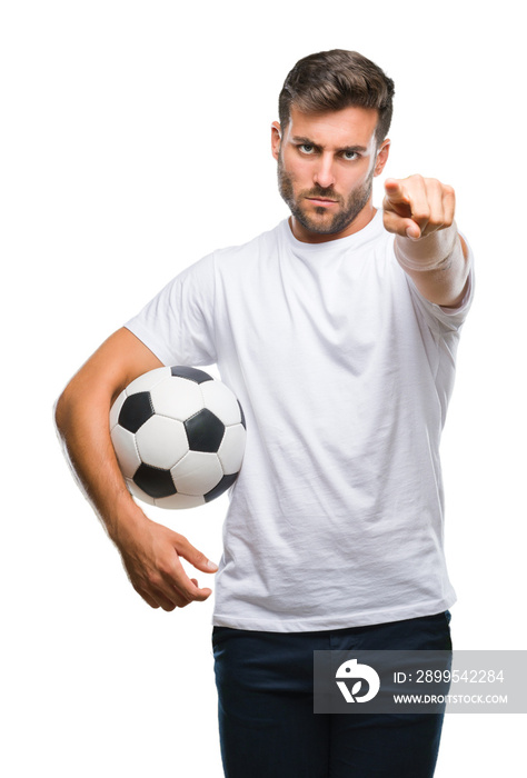 Young handsome man holding soccer football ball over isolated background pointing with finger to the camera and to you, hand sign, positive and confident gesture from the front