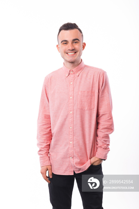 Cheerful young man, in pink shirt, standing over white background