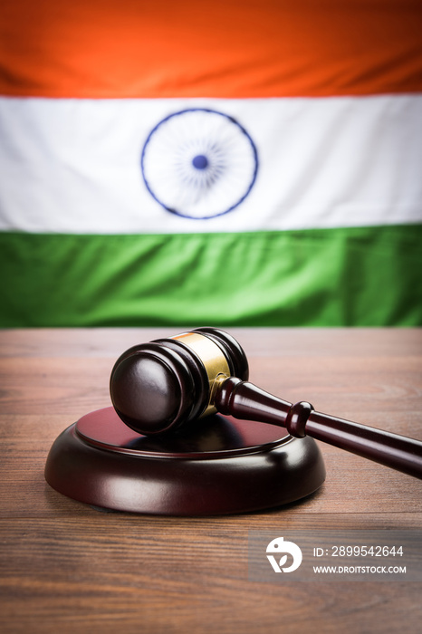 stock photo showing Indian low and jurisdiction - Indian national flag or tricolour with wooden gavel showing concept of law in India