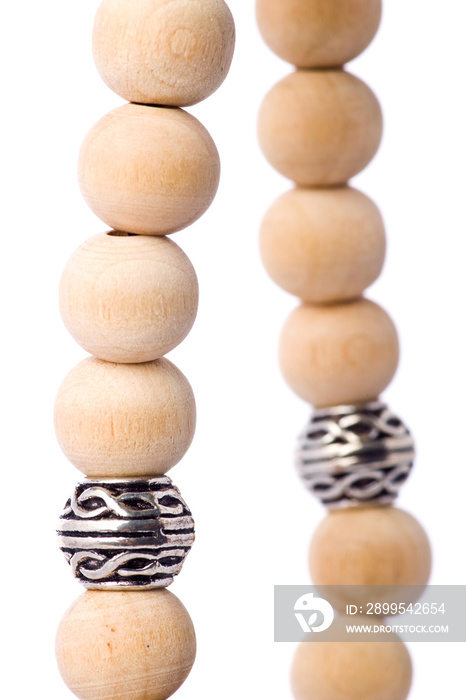 Closeup of a bracelet of wooden beads with tibetan metal spacer on a white background