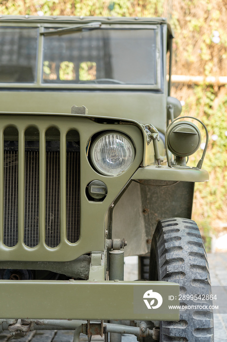 Glass car headlight and grille, cooling fan. Fragment of old army jeep vehicle, closeup. India