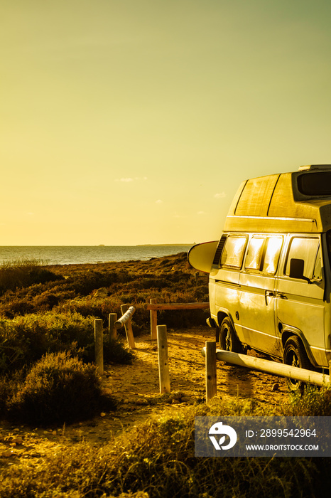 Camper van with surf board on beach