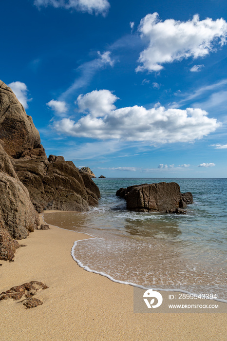 Rock formations and the sandy beach, at Porthcurno on the south coast of Cornwall