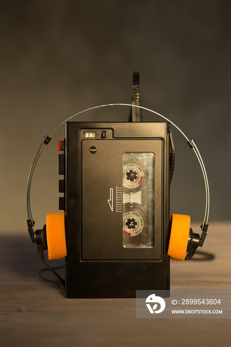 Old portable cassette player and headphones on a abstract background. Vintage advertisement style