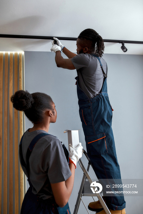 Handyman replacing light bulb in ceiling lamp