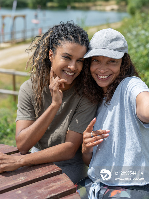 Portrait of smiling women sitting by picnic table