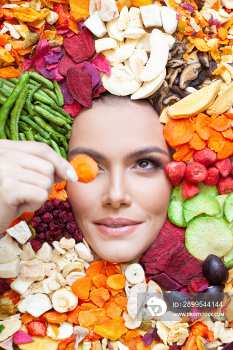 Pretty young woman with organic fruits and vegetables chips. Healthy snack eating