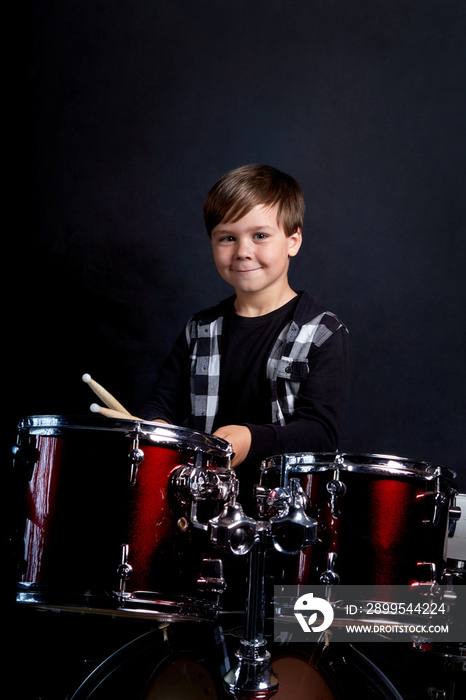 Beautiful brunette boy is rehearsing before a performance. Blue background.