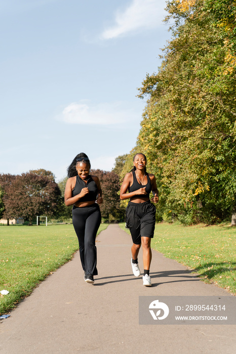 Young female friends jogging in park