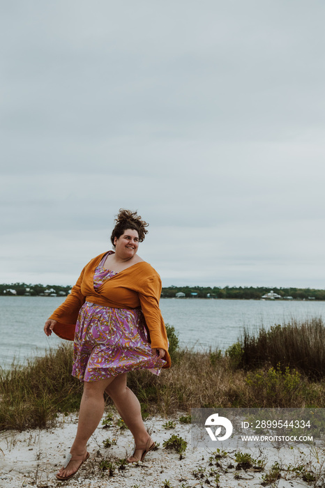 plus size woman walks on sand