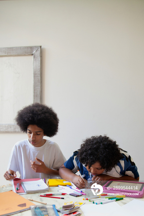 Two mixed-race brothers helping each other with homework