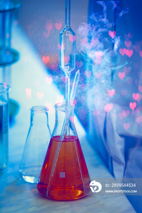 Glass laboratory flasks with chemical substance and magic glow. Making a magical love potion for fortune telling.