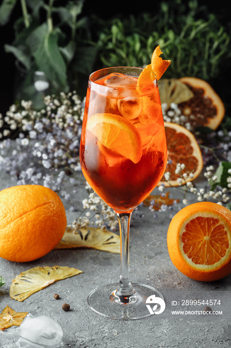 Aperol spritz cocktail on a gray concrete background. a glass of aperol spritz with orange slices. Summer cocktail in a glass