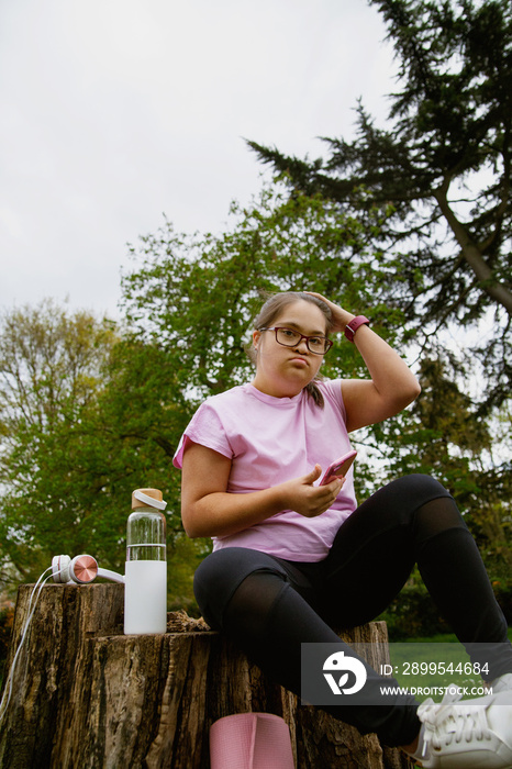 Young curvy girl with Down Syndrome taking selfie after workout