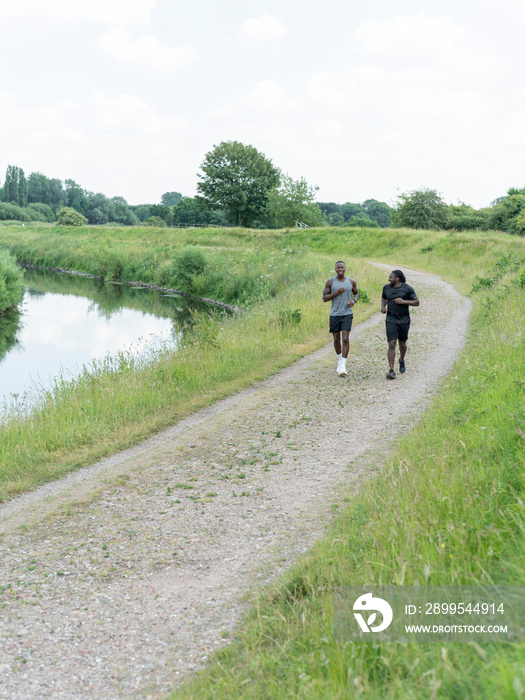 Two men jogging along river