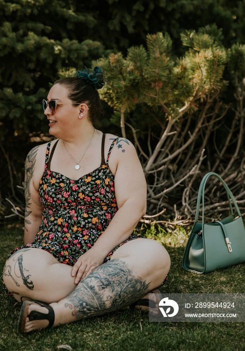 portrait of a plus size woman sitting on grass