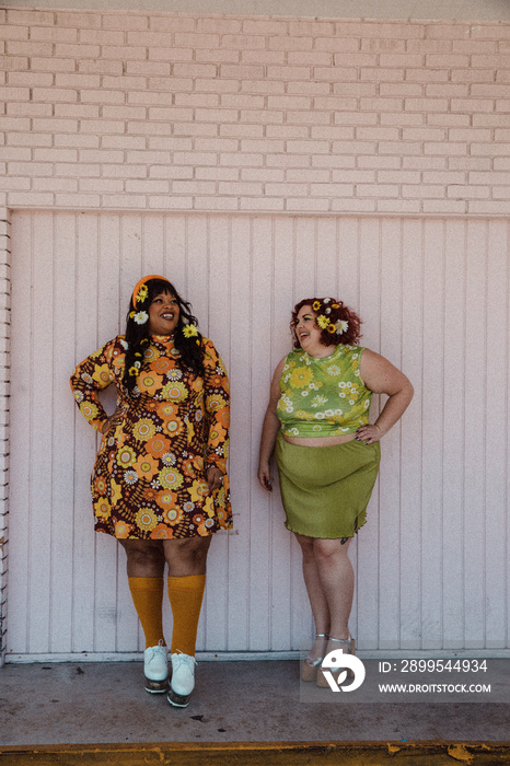 2 friends wearing retro dresses laughing