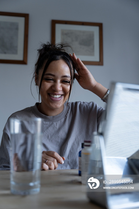 Smiling woman preparing hair in front of mirror at home