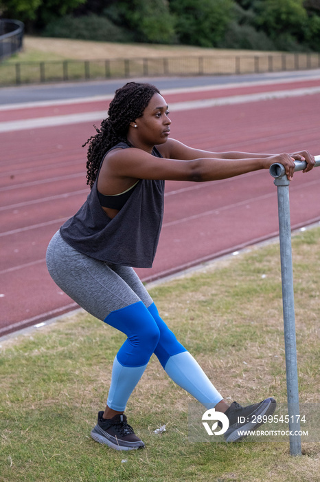 Athletic�woman stretching legs on running track