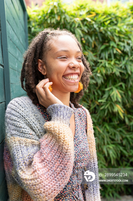 Portrait of young woman laughing while standing in garden