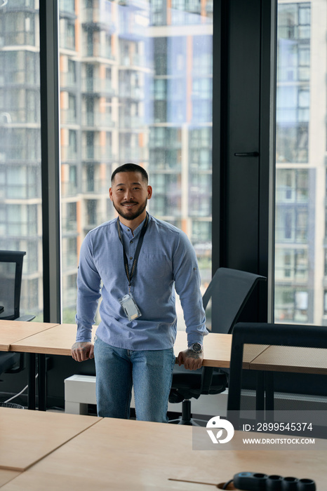 Happy corporate manager posing for camera in workplace