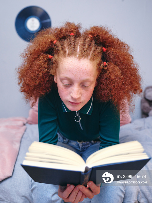 Girl reading book on bed