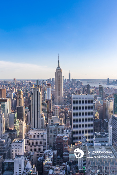 New York City Skyline in Manhattan downtown with Empire State Building and skyscrapers on sunny day with clear blue sky USA