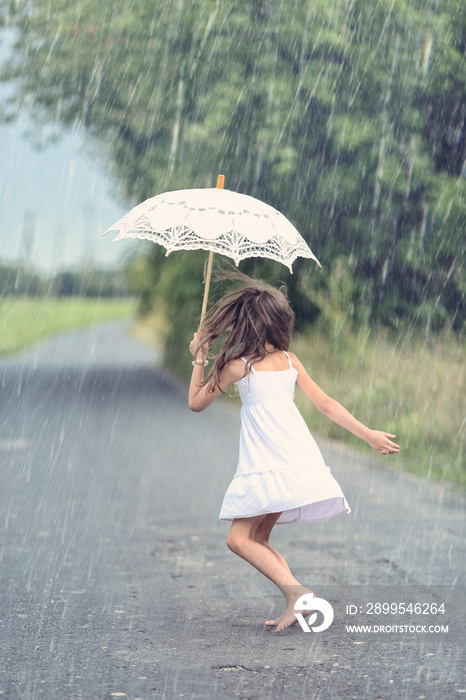 Joyful girl dance with umbrella in rain