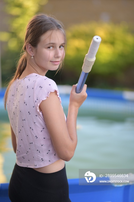 une belle fille nettoyage piscine extérieure à filet cuillère