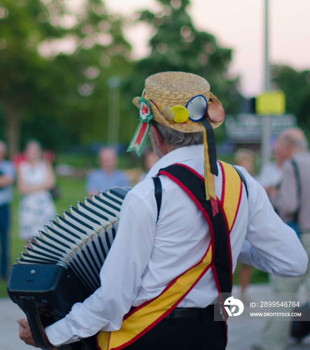 Traditional morris men dancing in the UK with sticks bells and musical instrument